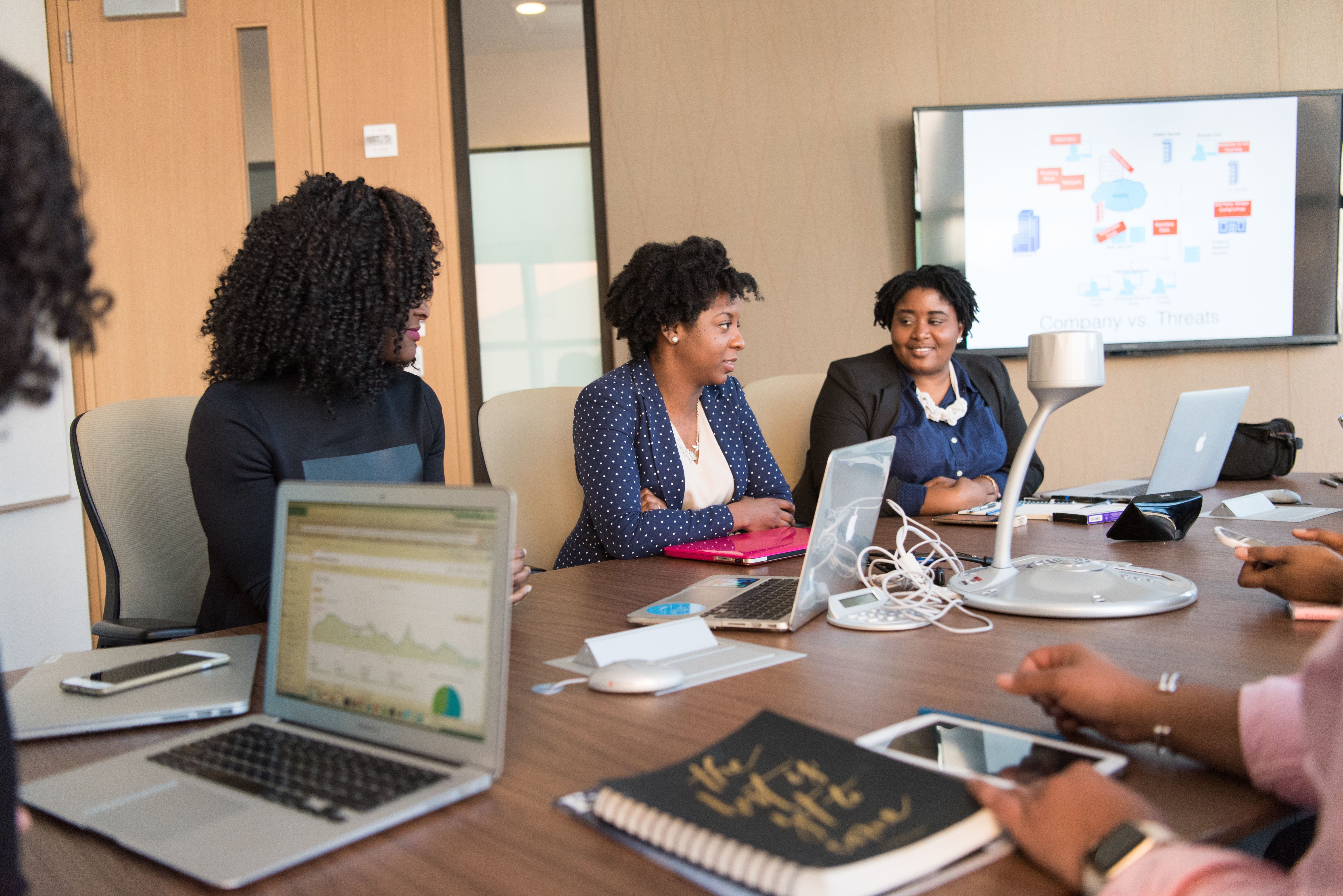 A team reviewing website concepts together around a laptop in a meeting room