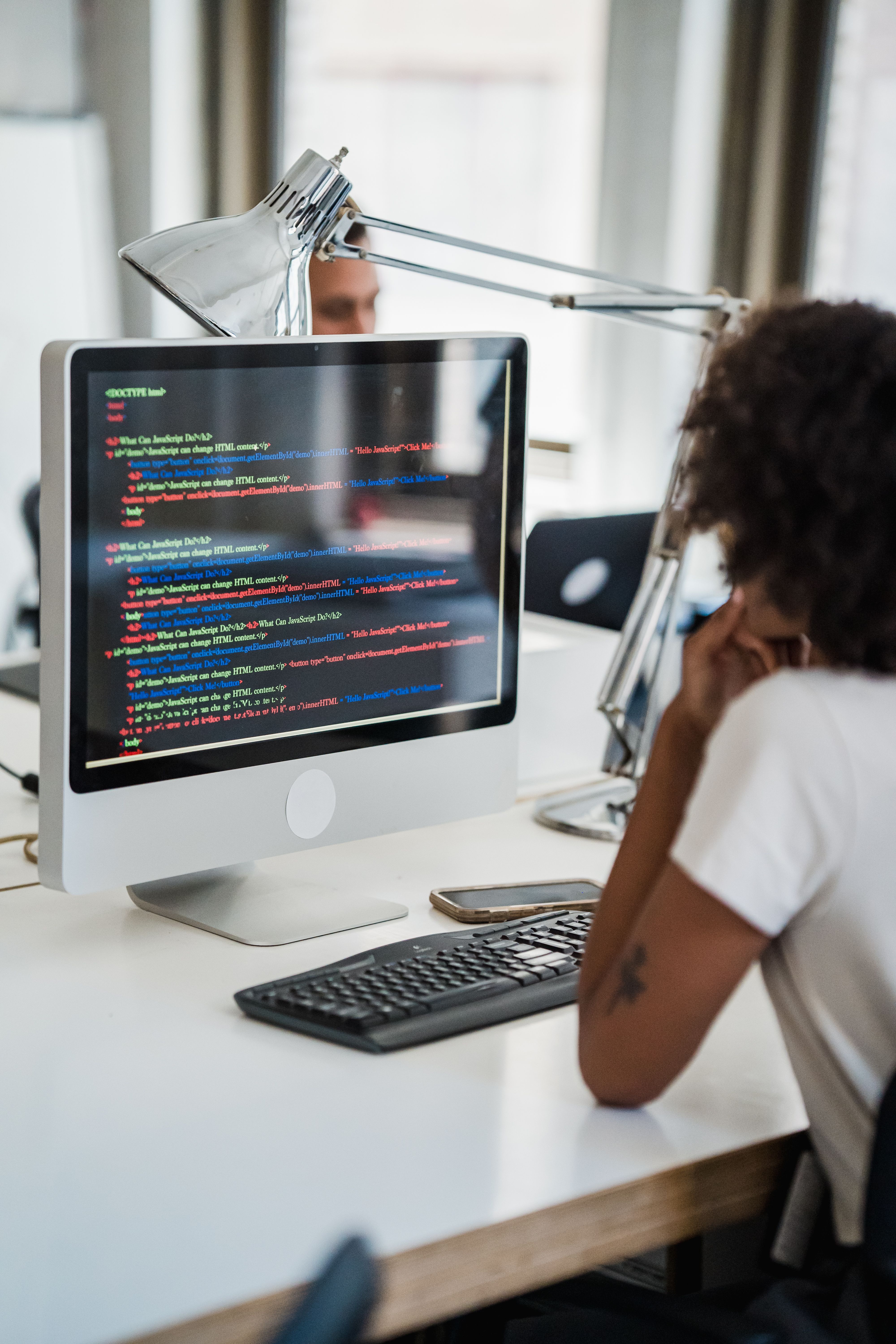A monitor displaying website code being written
